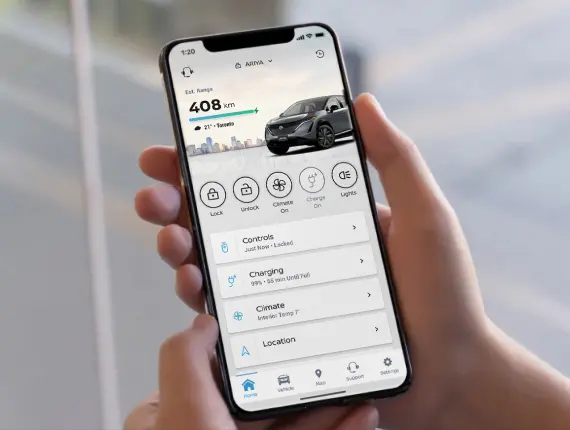 A user holding a mobile device with the MyNISSAN mobile app open.